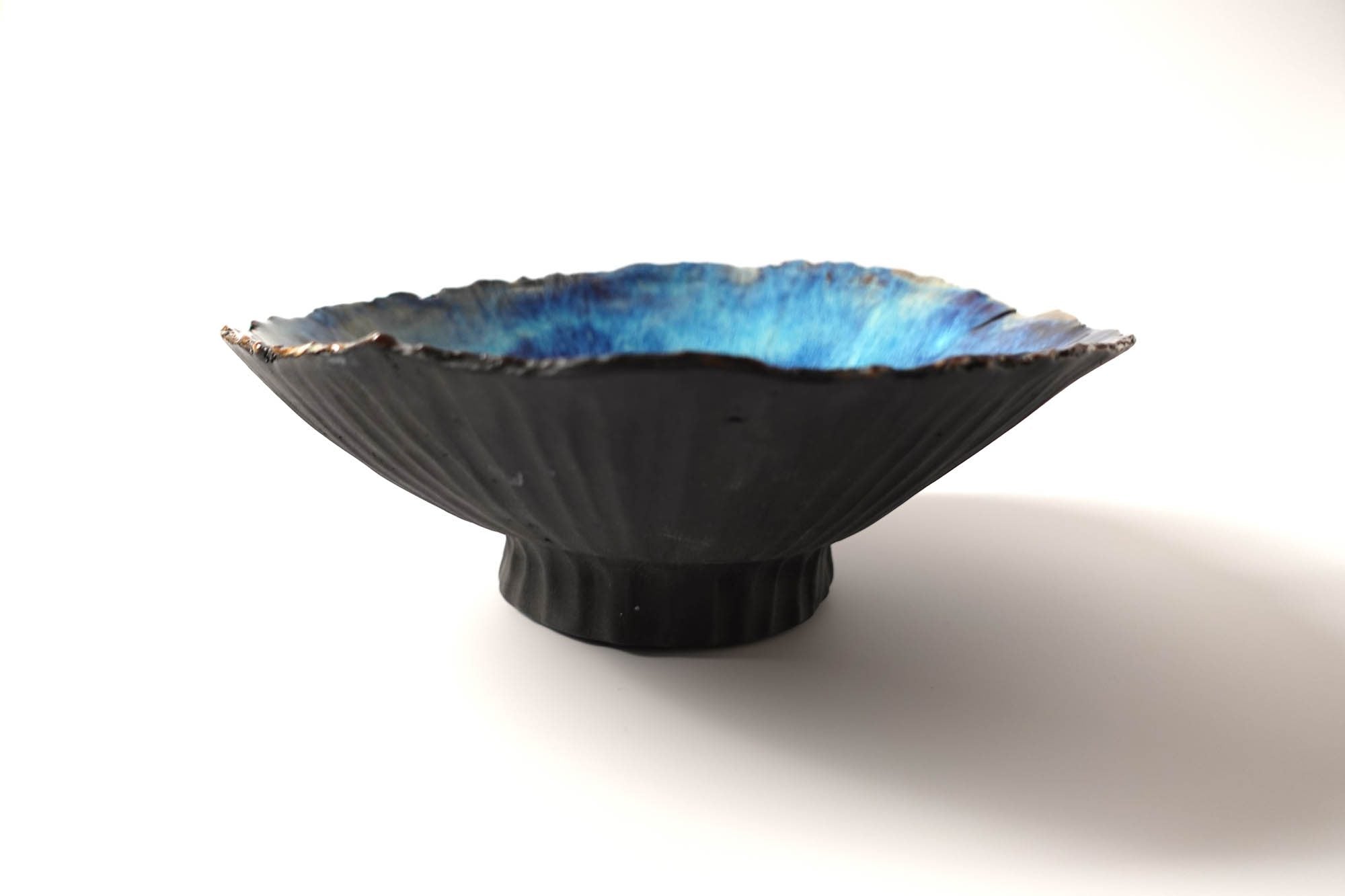 Footed ceramic bowl in black clay with a glossy blue glaze interior, made for Chef Bruno Verjus