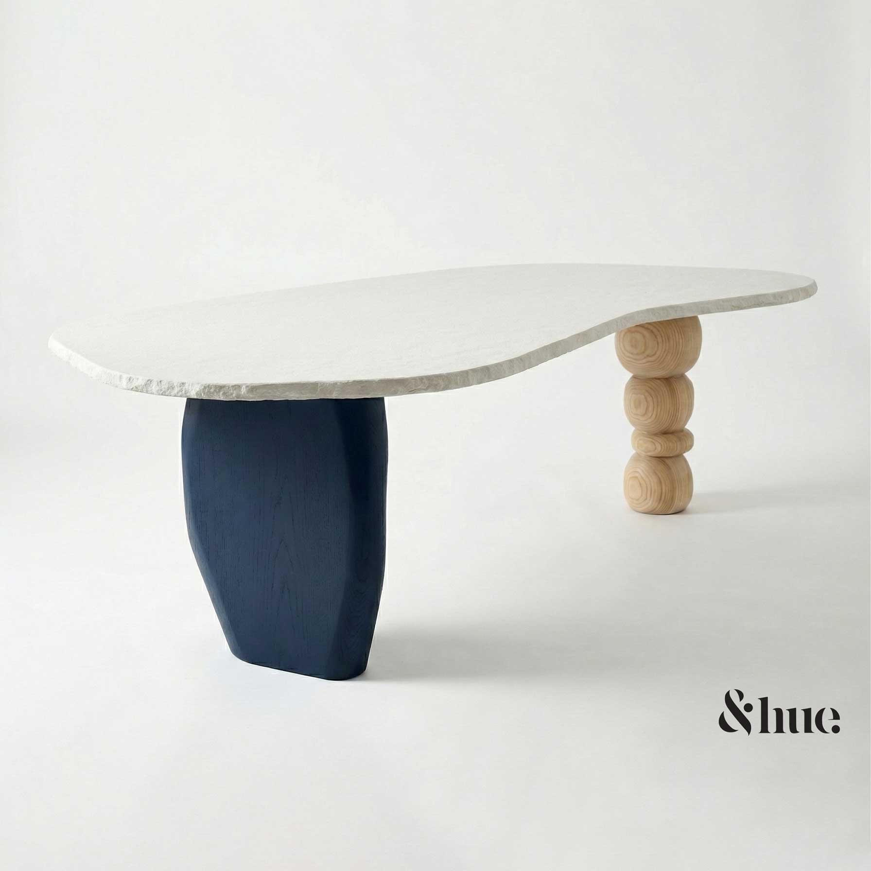 Sculptural low table with a white top and navy and wooden legs, a 2026 colour reference