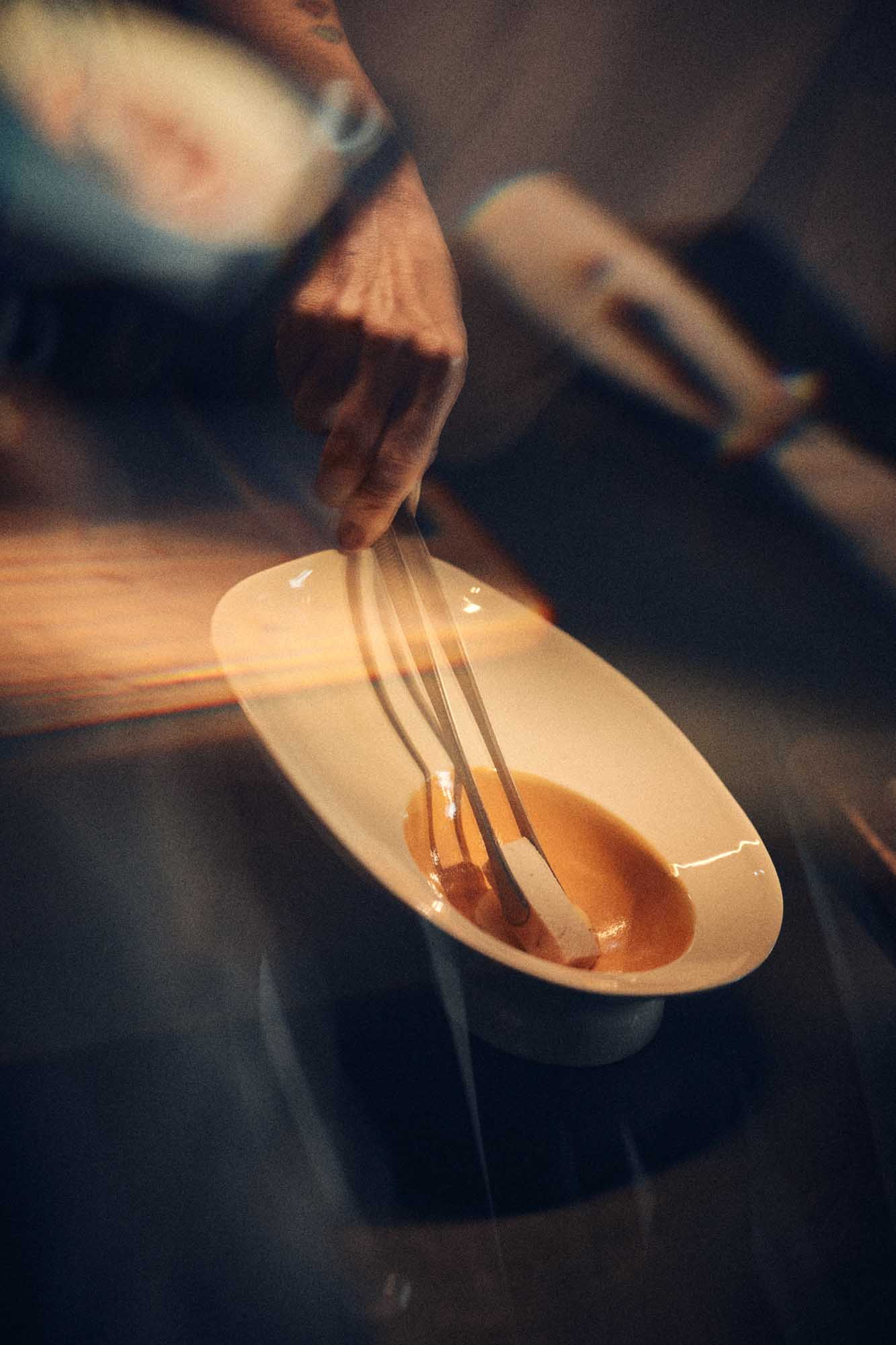 Spoon lifting food from the white porcelain Ab Ovo bowl, Materia Mensa Episode 2