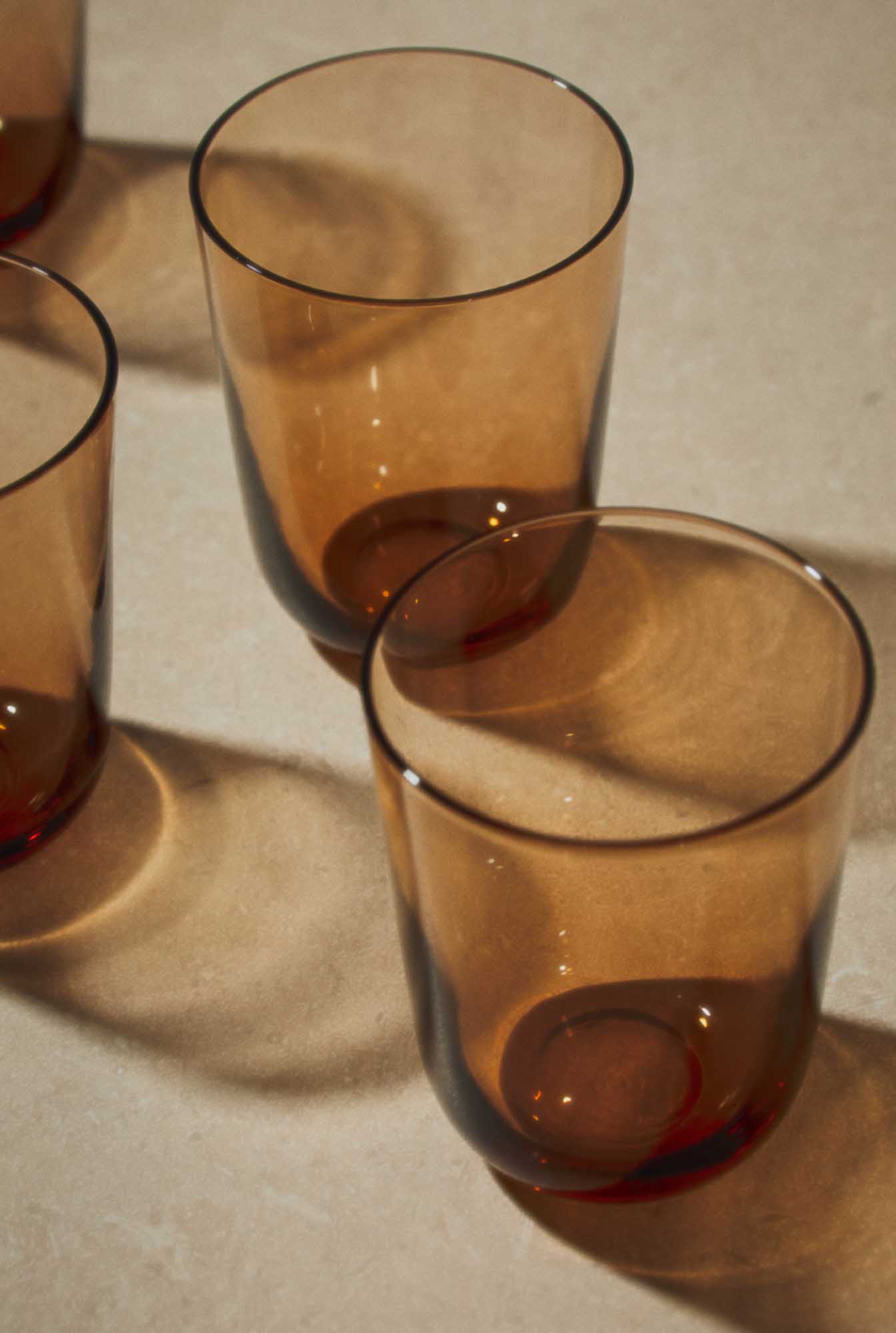 Amber glass tumblers casting warm shadows, a mood reference for autumn tableware colours